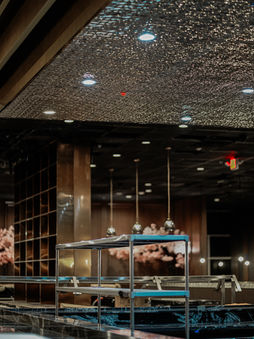 Black marble sushi bar under pendant lights at Umiya Raleigh