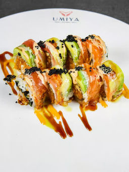 Sushi roll topped with salmon, avocado and black tobiko