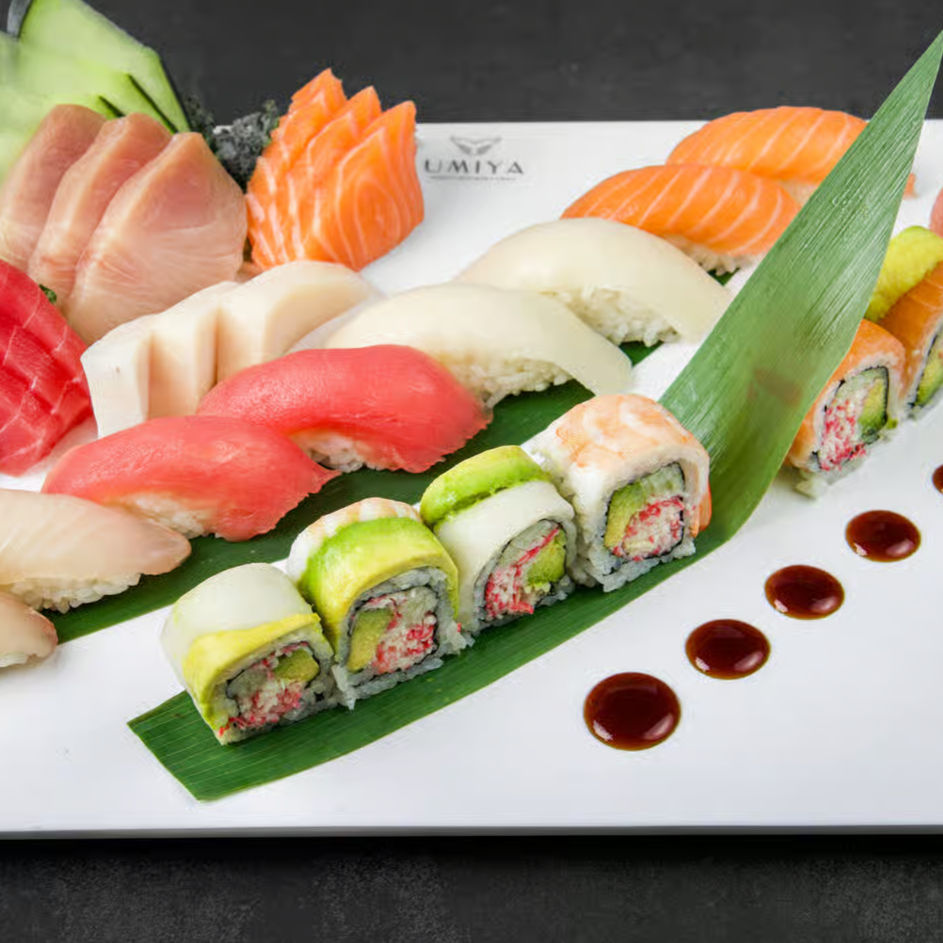 Assorted sashimi, nigiri, and specialty rolls on banana leaves at Umiya Raleigh